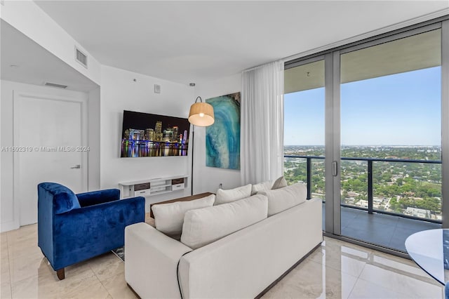 living room featuring a wall of windows and light tile patterned floors