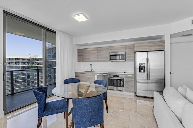 dining space featuring expansive windows and sink