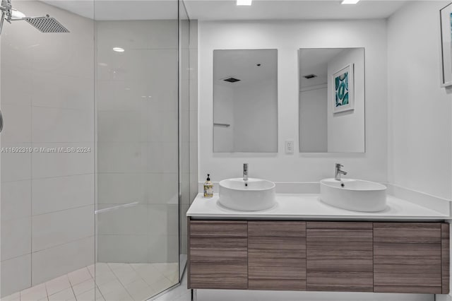 bathroom with vanity and a tile shower