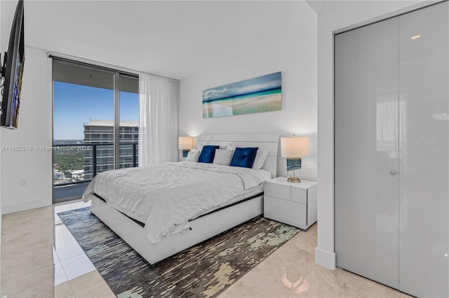 bedroom featuring access to outside, expansive windows, and a closet