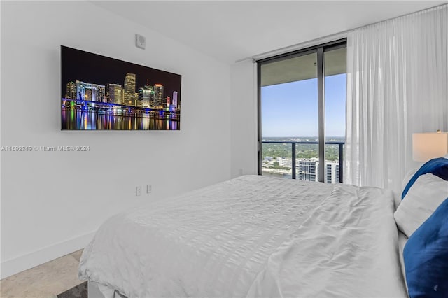 121 NE 34th St Unit 3116, Miami, FL 33137 - bedroom featuring a wall of windows, baseboards, and access to exterior