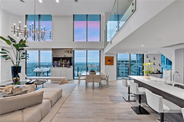 121 NE 34th St Unit Ph3217, Miami, FL 33137 - living area with a chandelier, a towering ceiling, baseboards, and light wood-type flooring