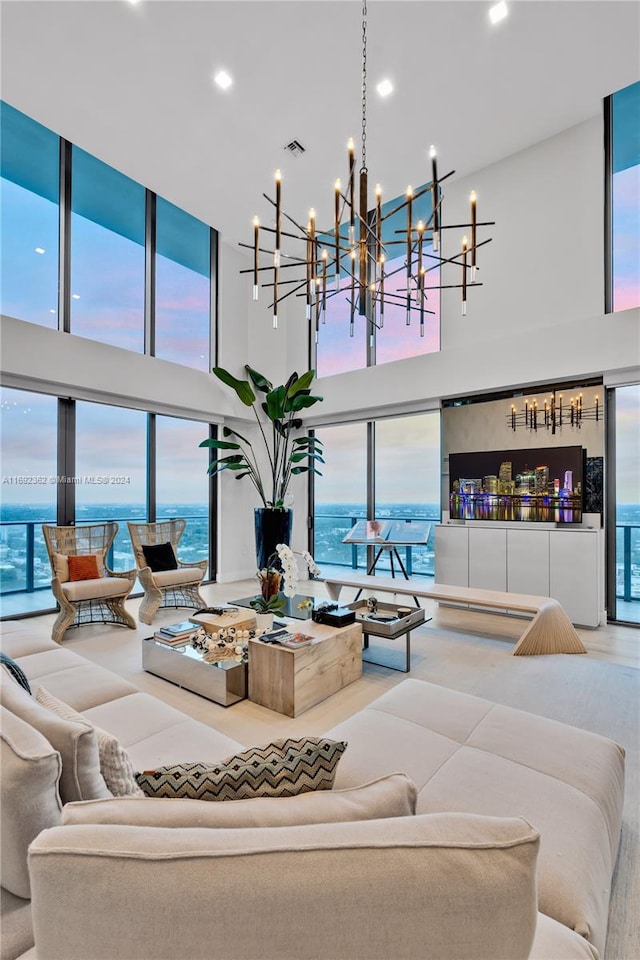 living room featuring a wealth of natural light, a towering ceiling, and a water view