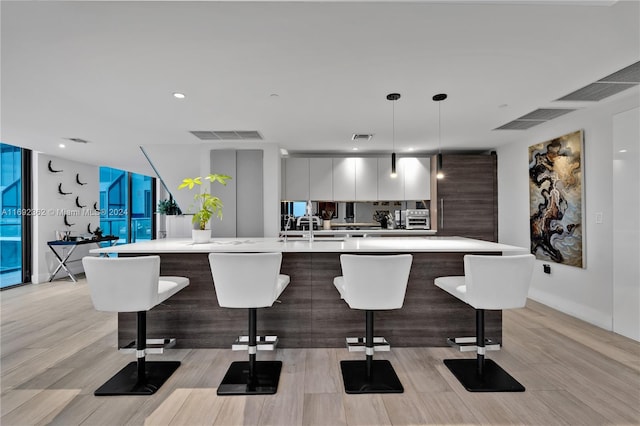 kitchen with decorative light fixtures, a large island with sink, and a kitchen breakfast bar