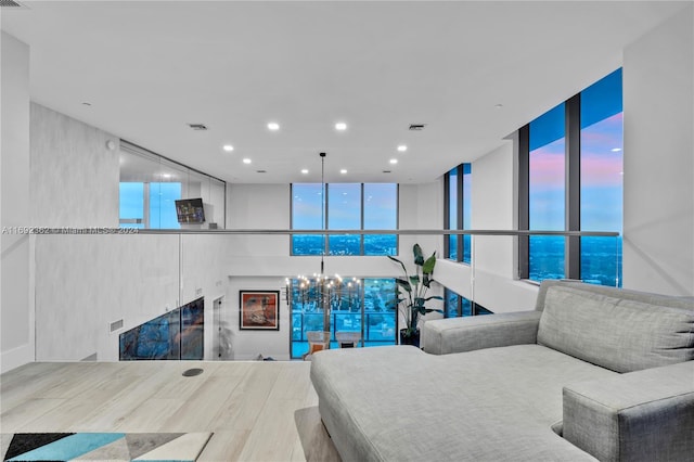 living room featuring expansive windows, plenty of natural light, and a notable chandelier