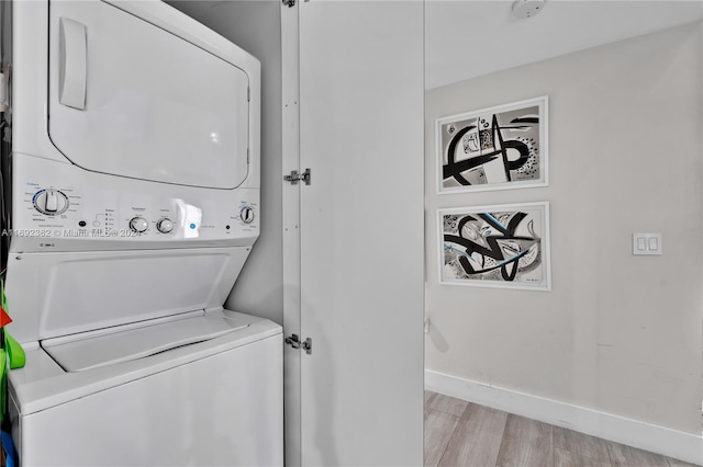 clothes washing area with stacked washer and dryer and light hardwood / wood-style flooring