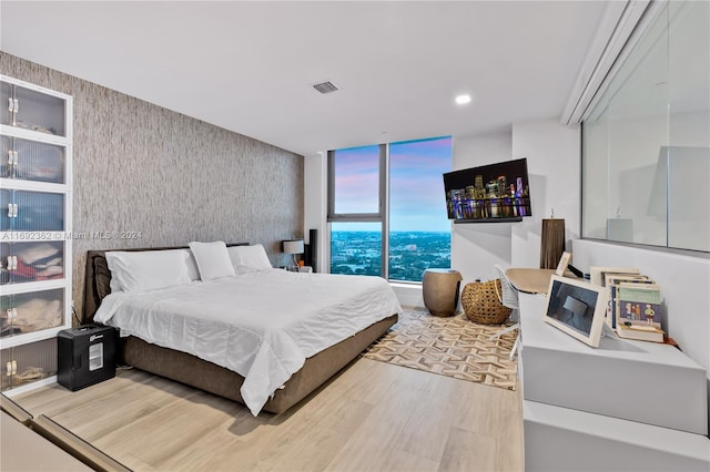 bedroom with hardwood / wood-style floors and expansive windows