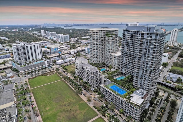 aerial view at dusk featuring a water view