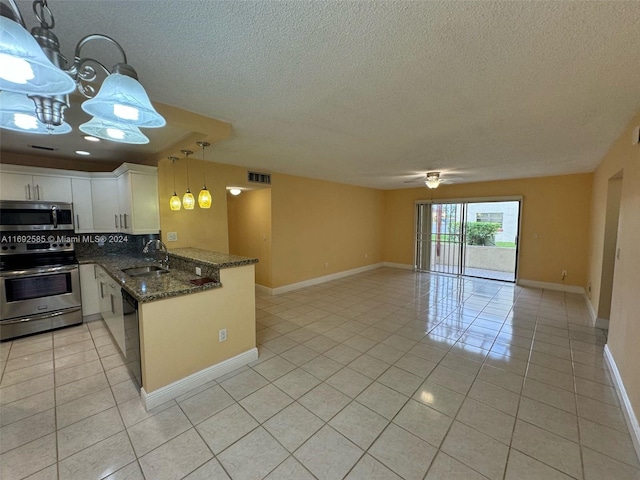 kitchen with stainless steel appliances, decorative light fixtures, sink, white cabinets, and kitchen peninsula