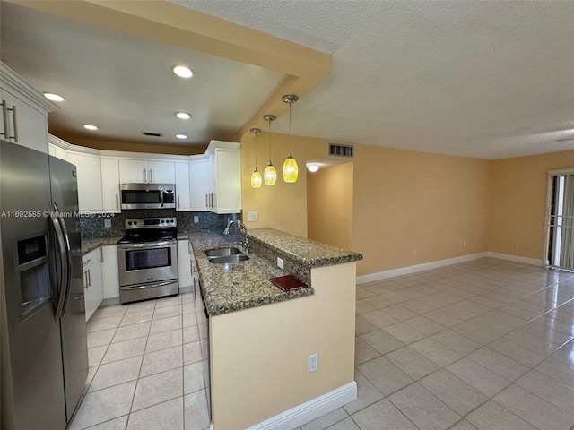 kitchen with sink, appliances with stainless steel finishes, backsplash, hanging light fixtures, and white cabinets