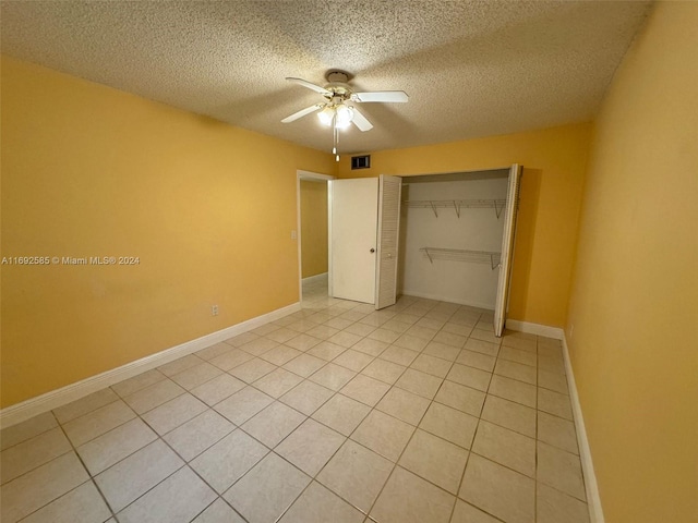 unfurnished bedroom with a closet, a textured ceiling, light tile patterned floors, and ceiling fan