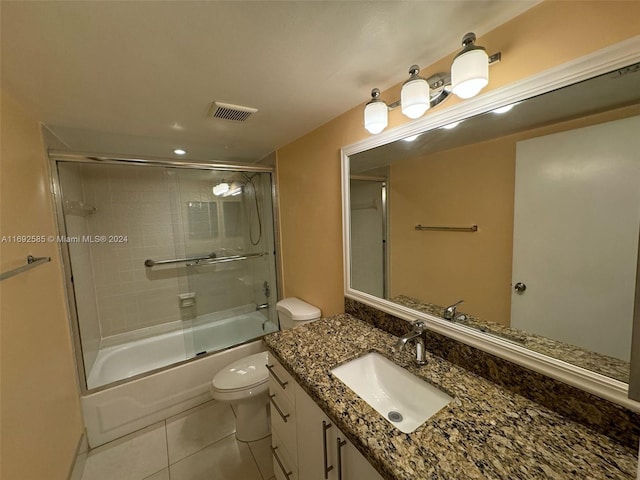 full bathroom with shower / bath combination with glass door, tile patterned flooring, toilet, and vanity