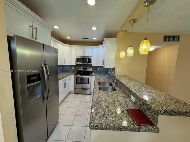 kitchen with stainless steel appliances, white cabinets, hanging light fixtures, sink, and backsplash