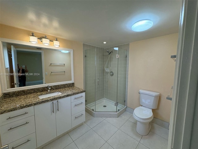 bathroom with tile patterned flooring, an enclosed shower, vanity, and toilet