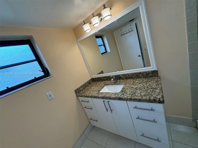 bathroom with vanity, tile patterned flooring, and a healthy amount of sunlight