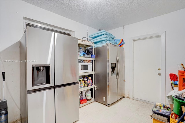 kitchen with stainless steel fridge and a textured ceiling