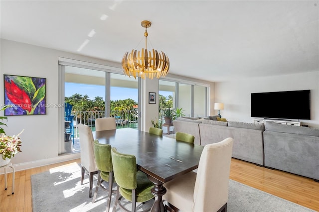 dining area featuring light hardwood / wood-style floors and an inviting chandelier