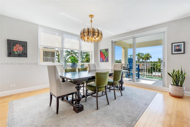 dining space featuring hardwood / wood-style flooring and a notable chandelier