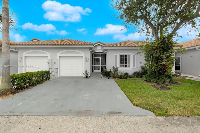 mediterranean / spanish house featuring a garage and a front yard