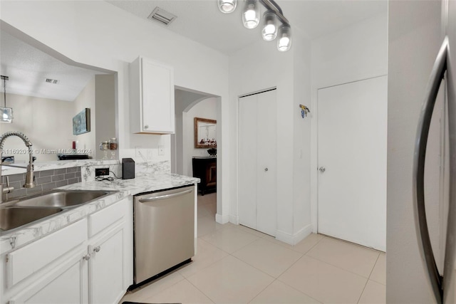 kitchen with white fridge, pendant lighting, sink, white cabinets, and stainless steel dishwasher