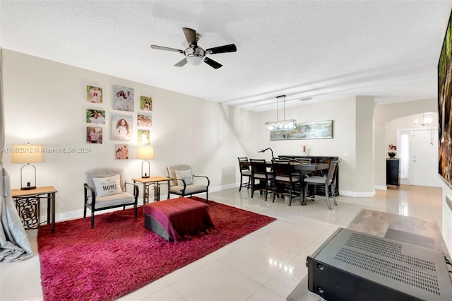 living room with tile patterned floors, a textured ceiling, and ceiling fan