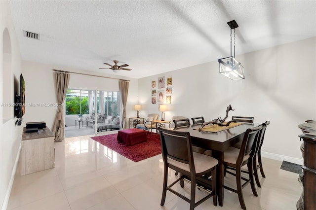 dining area featuring a textured ceiling, ceiling fan, and light tile patterned flooring