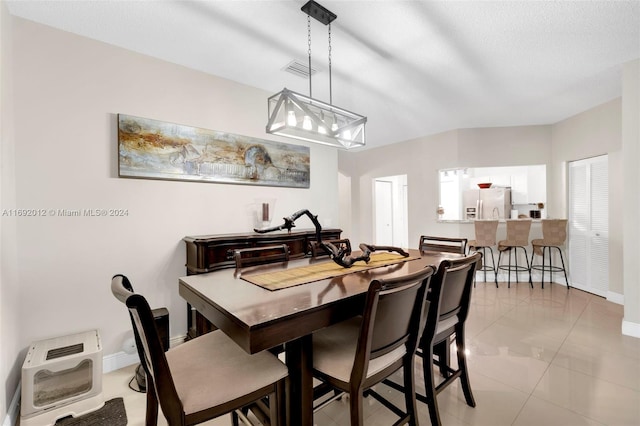 tiled dining space with heating unit and a textured ceiling