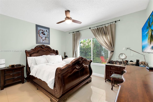 bedroom with light tile patterned flooring, ceiling fan, and a textured ceiling