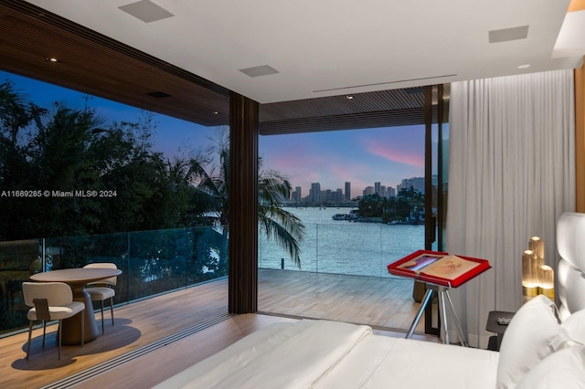 bedroom featuring a water view, hardwood / wood-style floors, and floor to ceiling windows