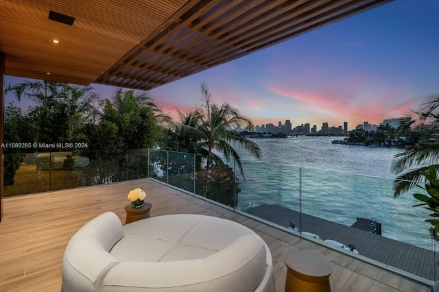 balcony at dusk with a water view and an outdoor living space