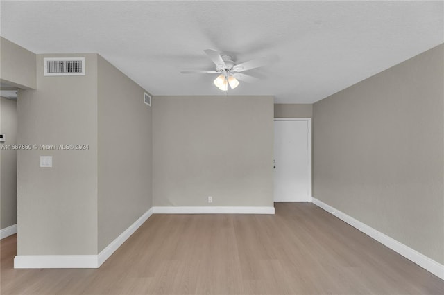 spare room featuring a textured ceiling, light hardwood / wood-style floors, and ceiling fan