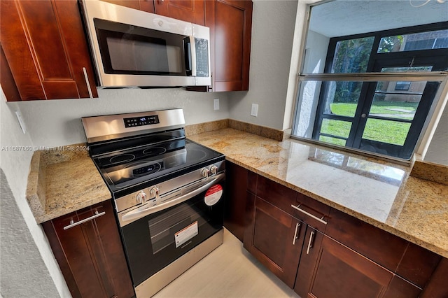 kitchen featuring stainless steel appliances and light stone countertops