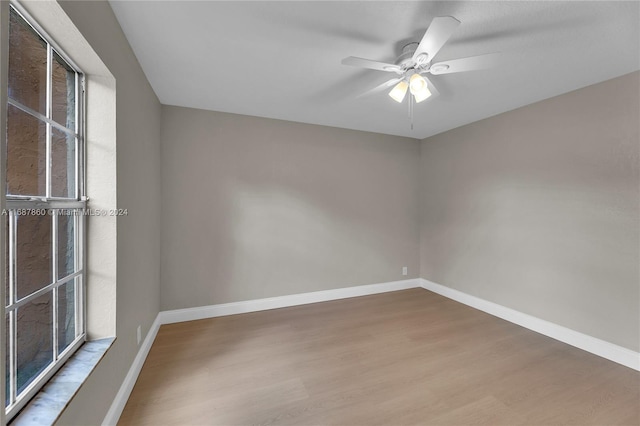 unfurnished room with hardwood / wood-style floors, a wealth of natural light, and ceiling fan