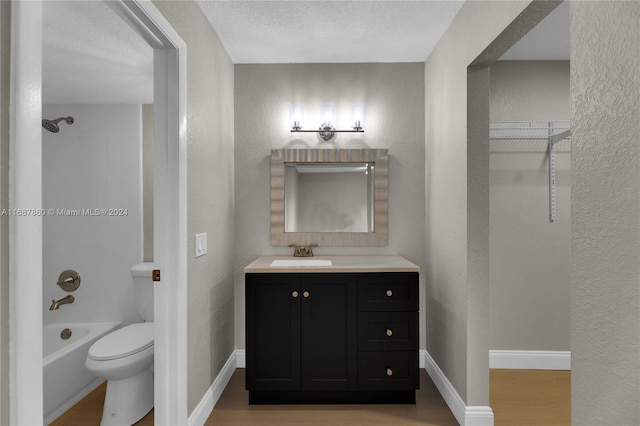 full bathroom featuring shower / bathtub combination, vanity, a textured ceiling, hardwood / wood-style flooring, and toilet