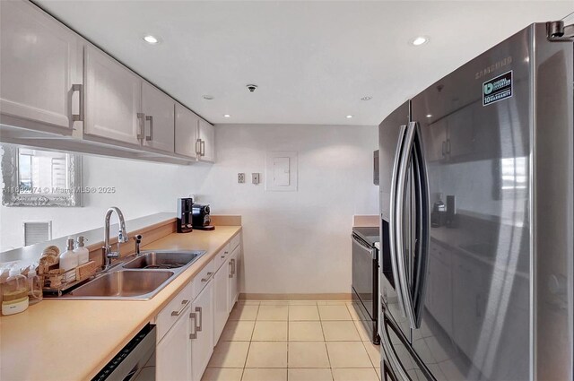 kitchen with white cabinets, light tile patterned floors, sink, and appliances with stainless steel finishes