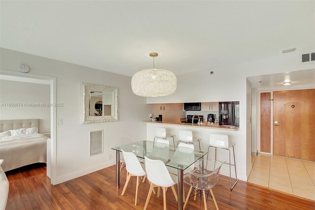 dining area with hardwood / wood-style flooring and sink