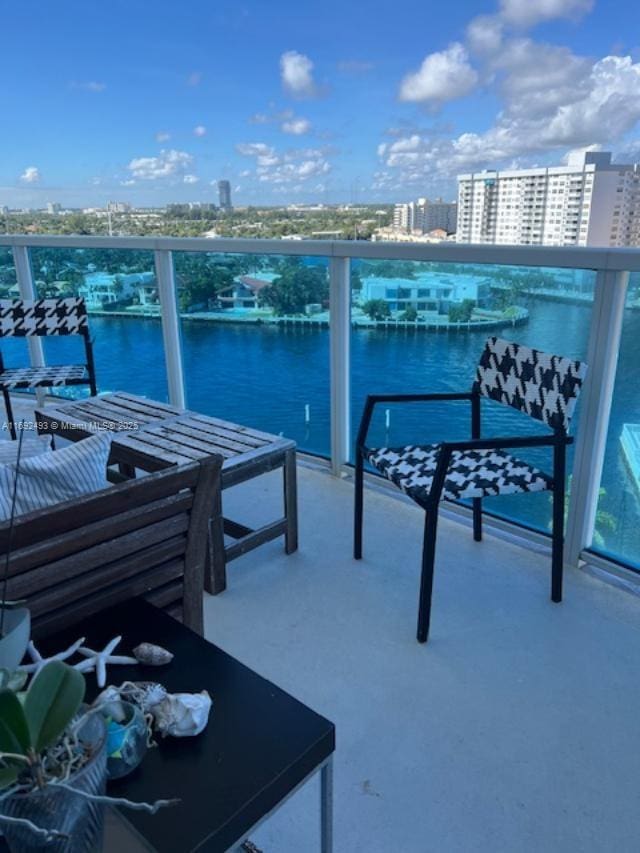 balcony featuring a water view and a city view