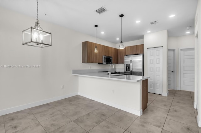 kitchen featuring stainless steel appliances, sink, kitchen peninsula, decorative light fixtures, and a notable chandelier