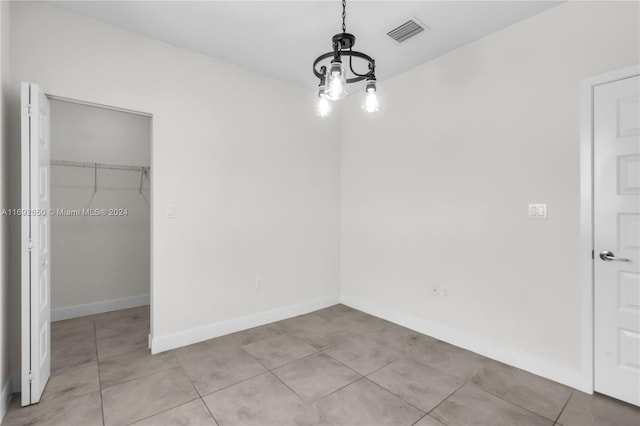 unfurnished dining area featuring a chandelier and light tile patterned floors