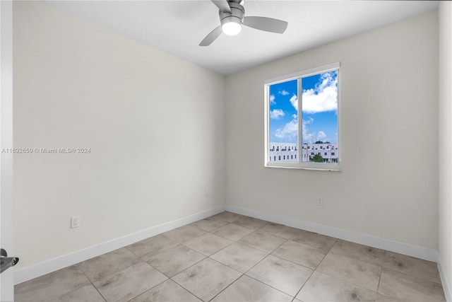 tiled empty room featuring ceiling fan