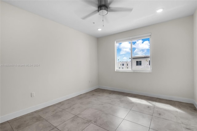 tiled spare room featuring ceiling fan