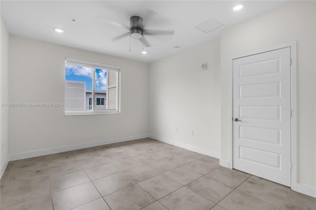 tiled empty room featuring ceiling fan