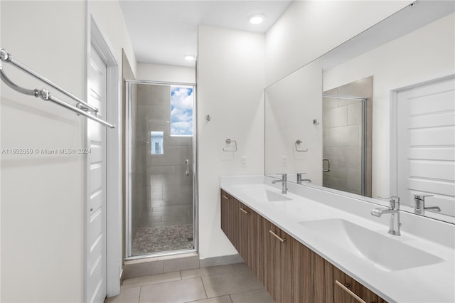 bathroom with vanity, a shower with door, and tile patterned flooring