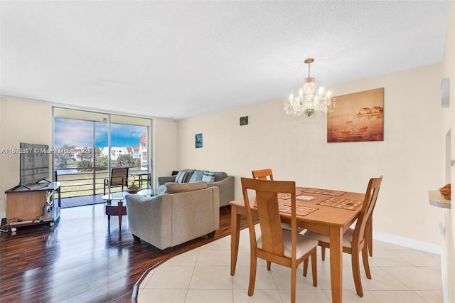 dining area featuring expansive windows, a chandelier, light hardwood / wood-style floors, and a textured ceiling