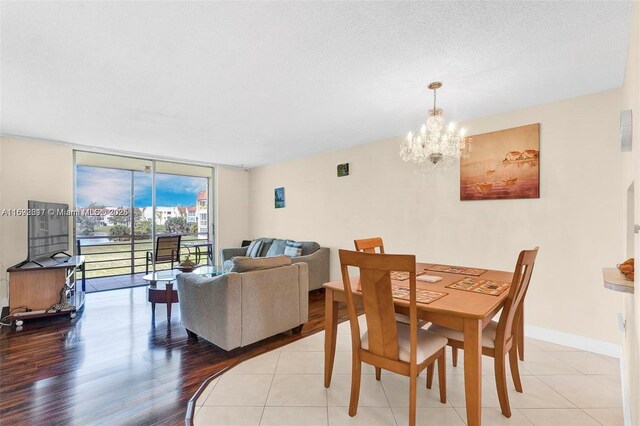 2951 E Sunrise Lakes Dr Unit 209, Sunrise, FL 33322 - dining space with a wall of windows, a chandelier, baseboards, and wood finished floors
