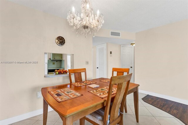 2951 E Sunrise Lakes Dr Unit 209, Sunrise, FL 33322 - dining area featuring a chandelier, light tile patterned floors, baseboards, and a textured ceiling