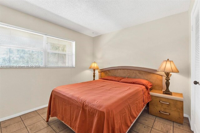 2951 E Sunrise Lakes Dr Unit 209, Sunrise, FL 33322 - bedroom featuring a textured ceiling and baseboards