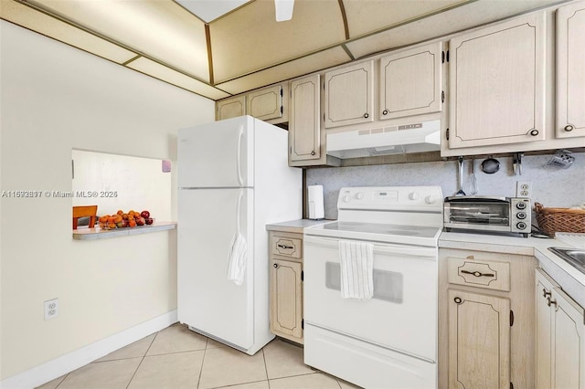 kitchen featuring a drop ceiling, light tile patterned floors, and white appliances