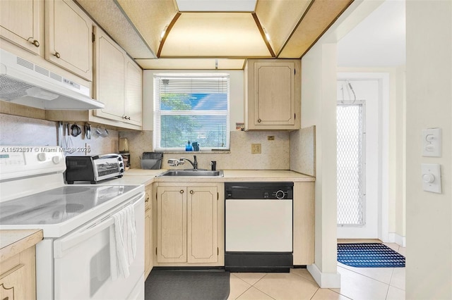 kitchen with light brown cabinetry, light tile patterned floors, white appliances, and sink