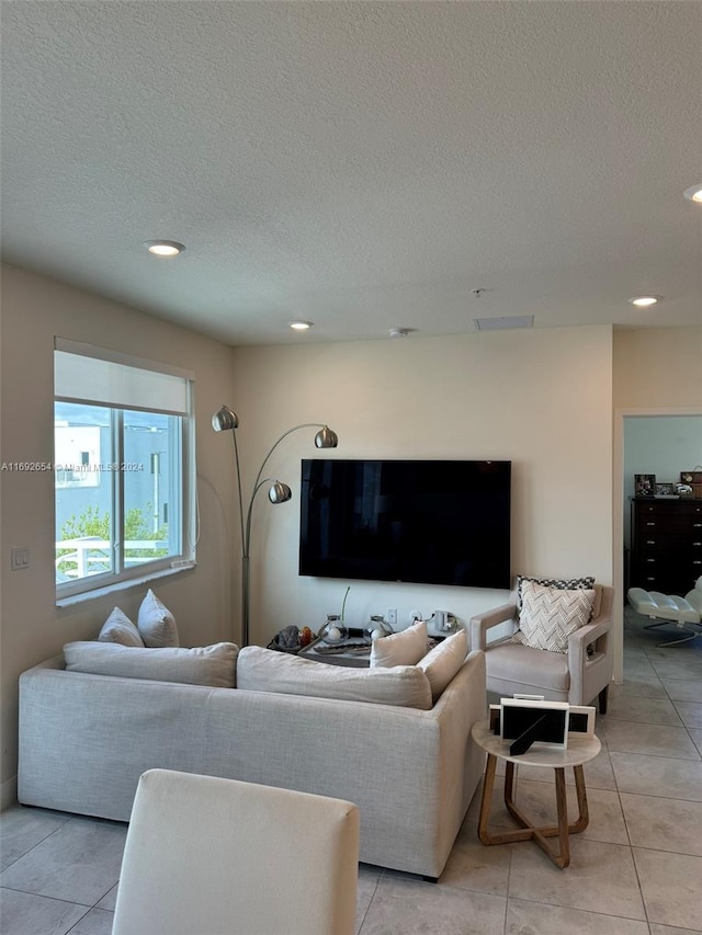 tiled living room featuring a textured ceiling